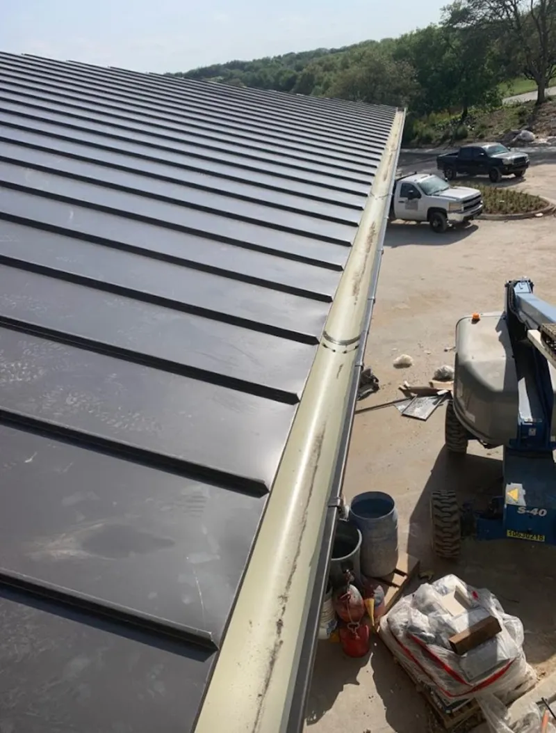 Standing seam panel and gutter detail on a metal roofing jobsite in Port Washington